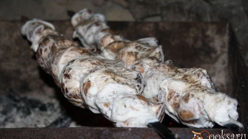 луговые шампиньоны в жировой сетке на мангале