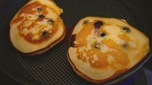 банановые оладьи с кленовым сиропом, голубикой и орехами пекан